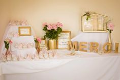 a table topped with lots of pink flowers next to a sign that says meroh