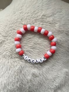 a red and white beaded bracelet with the word babies on it