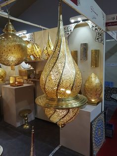 gold colored lights hanging from the ceiling in a room filled with furniture and decor items