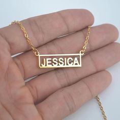 This modern Personalized Name Necklace features a cut-out name placed into a square bar. The name bar gives this piece a unique look that is sure to catch eyes! Choose to have a name or word up to 10 letters. Material: Stainless Steel plated in 18K gold Customized Rectangular Gold Necklace, Modern Personalized Rectangular Jewelry, Modern Gold Name Necklace For Gifting, Modern Gold Name Necklace For Gift, Modern Personalized Rectangular Necklaces, Modern Gold Name Necklace, Gold Engraved Name Necklace Rectangular, Gold Engraved Rectangular Name Necklace, Yellow Gold Rectangular Bar Necklace