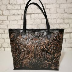 Featuring a gorgeous artisan design, this rustic HAND TOOLED LEATHER PURSE will help you bring a little VINTAGE flair to your everyday outfit.🌸 The perfect size for fitting all of your everyday essentials, this purse was actually HANDMADE with love and care by talented artisans , giving it a rustic touch that’s hard to find in stores. This purse comes CHISELED both sides, one side with floral design and another side with a skull design.Crafted from genuine cowhide leather and best for casual an Black Hand Tooled Tote Shoulder Bag, Rustic Brown Hand Tooled Bag, Rustic Brown Hand Tooled Shoulder Bag, Luxury Vintage Hand Tooled Bag, Leather Hand Tooled Shoulder Bag For Western-themed Events, Skull Bags, Tooled Leather Purse, Tooled Leather Bag, Bags Leather Handbags