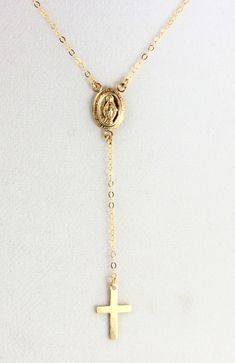 "Cross necklace rosary inspired Lariat made of 14kt Gold filled. A beautiful gold filled Miraculous medallion hangs from the center. A very simple gold filled cross pendant hangs from the 2 1/4\" drop. Necklace may be ordered in a 16\", 18\" or 20\" length, priced accordingly. The length is the measurement around the neck only. Necklace has spring clasp closure and comes nicely boxed, the perfect gift! *May also be purchased in Sterling Silver or Rose Gold Filled as seen in last photo. Necklace Dainty Gold Crucifix Jewelry, Gold Cross Lariat Necklace As Gift, Minimalist Gold Crucifix Jewelry, Elegant Cross Lariat Necklace, Elegant Gold Cross Lariat Necklace, Gold Adjustable Minimalist Cross Necklace, Adjustable Gold Cross Lariat Necklace, Yellow Gold Crucifix Necklace With Delicate Chain, Adjustable Yellow Gold Crucifix Jewelry