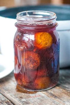 a jar filled with pickles sitting on top of a wooden table