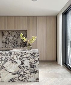 a marble counter top in a room with wood paneling and large glass doors leading to the outside