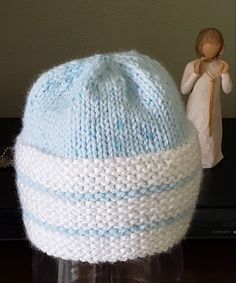 a knitted blue and white hat next to a figurine