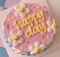 a birthday cake with the words happy day written on it, surrounded by flowers and bees