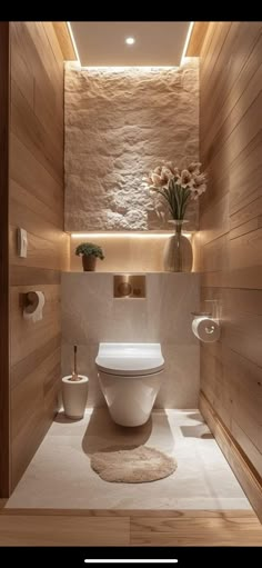 a modern bathroom with wooden walls and flooring, including a toilet in the center