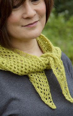 a woman wearing a gray shirt and a yellow knitted cowl around her neck