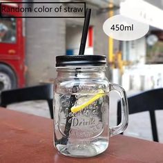 a mason jar with a straw in it sitting on a table