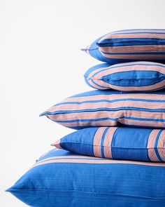 four blue pillows stacked on top of each other