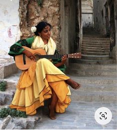 a woman sitting on steps playing a guitar