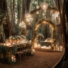 an outdoor dinner table with candles and chandeliers in the woods, surrounded by lush greenery