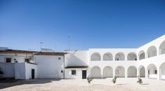 an empty courtyard with white walls and arches