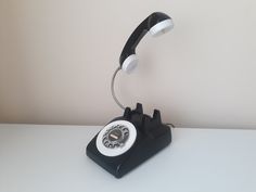 an old - fashioned phone sits on top of a white table and is turned off