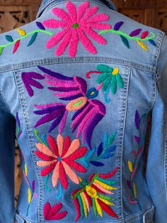 a denim jacket with embroidered flowers on it