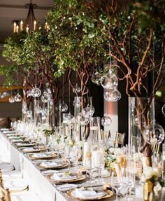 a long table is set up with place settings and centerpieces for an elegant dinner