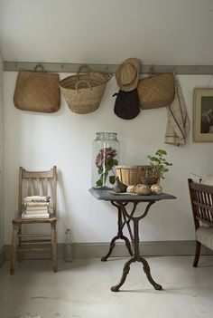 there are baskets hanging on the wall above a table