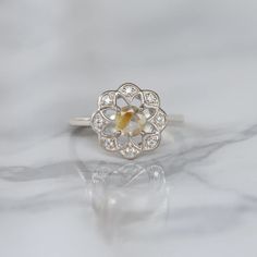 Sometimes when a girl says she likes to receive flowers as a gift, it's not the real flowers she means. Think twice and go for the safest thing - our Flora ring with Golden Rutile Ring with Moissanite. Floral jewelry is where it's at! Perfect as a graduation gift, birthday gift, anniversary ring, or a promise ring. Det Rose Cut Diamond Flower Promise Ring, Heirloom Flower Ring With Rose Cut Diamonds As Gift, Heirloom Rose Cut Diamond Flower Ring As Gift, White Gold Gemstone Promise Ring, Diamond Flower Ring With Birthstone For Anniversary, Anniversary White Gold Flower Ring With Gemstone, Silver Cluster Ring With Rose Cut Diamonds For Promise, White Gemstone Flower Ring For Promise, White Flower Ring With Gemstone For Promise