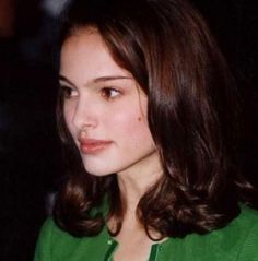 a young woman wearing a green shirt and necklace