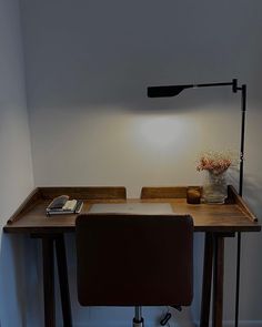 a desk with a lamp on it and a book sitting on top of the desk