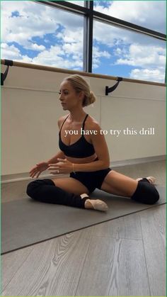 a woman is sitting on the floor doing yoga