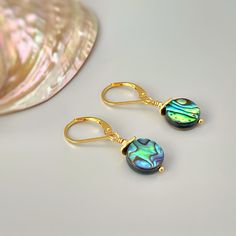 "Handmade Abalone Dangle Earrings.   Iridescent abalone shell rounds are set in your choice of 14k gold fill, sterling silver, or rose gold fill and hang from your choice of leverbacks or French hook ear wires.   Simple, elegant earrings perfect summer or beach wedding earrings. The matching necklace is available for purchase separately in our store. Abalone drops are dainty - about 3/8\" wide Overall Earring length - 1 1/4\" long PLEASE note measurements and size reference pictures. Our jewelry Iridescent Mother Of Pearl Dangle Jewelry, Abalone Shell Dangle Earrings With Matching Set, Gold Abalone Shell Earrings For Gifts, Handmade Gold Jewelry With Abalone Shell, Iridescent Abalone Shell Dangle Jewelry, Gold Abalone Shell Round Jewelry, Elegant Nickel-free Abalone Shell Jewelry, Elegant Gold Jewelry With Abalone Shell, Elegant Gold Abalone Shell Jewelry