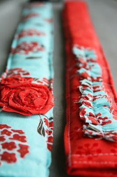 two pieces of fabric with red and blue flowers on them, one has a flower in the center