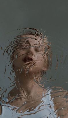 a woman's face is reflected in the water