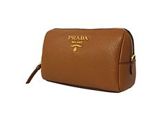 This Prada vanity case is so cute and coordinates beautifully with all of Prada's Vitello Daino leather collection! The size is perfectly compact to hold your essential cosmetic items that you may want to take with you on a trip or out for the day. Throw this in your handbag and store your items classically. Features a zip closure and gorgeous gold-tone Prada emblem on the front and a black lined interior.     Model: 1ND004  Cannella brown    Vitello Daino calfskin leather  Gold-tone hardware  P Luxury Brown Rectangular Cosmetic Bag, Luxury Brown Cosmetic Bag For Daily Use, Brown Round Case Bag For Formal Occasions, Brown Round Case Bag For Formal Events, Luxury Brown Cosmetic Bag For Travel, Luxury Brown Travel Cosmetic Bag, Luxury Brown Cosmetic Bag With Removable Pouch, Compact Brown Leather Bag, Brown Compact Formal Bag