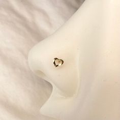 a pair of earrings sitting on top of a white cloth covered bed sheet with a heart shaped diamond in the middle