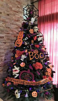 a decorated halloween tree in front of a brick wall