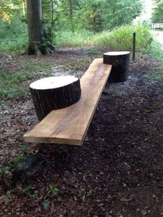 two wooden benches sitting in the middle of a forest