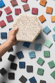 a hand is holding a box that has been made out of rice and colored blocks