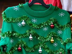 a green sweater with christmas decorations on it