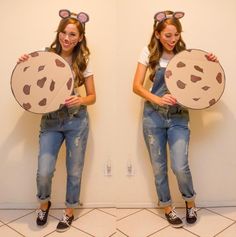 two girls wearing mouse ears holding up cookie cookies on their heads and one girl in overalls is smiling at the camera