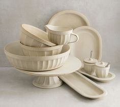 an assortment of white dishes and cups