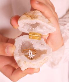 a person holding two pieces of jewelry in their hands, one with a ring on it