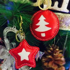 two red and white ornaments hanging from a christmas tree