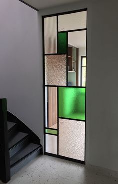 an open door with multiple colored glass panels on the front and back doors, along with a stair case