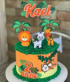 a two tiered cake decorated with jungle animals