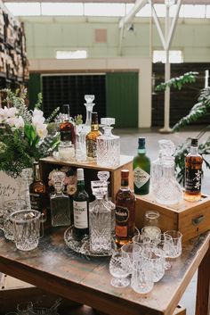 an assortment of liquor bottles and glasses on a table