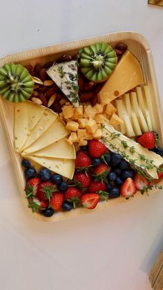 a platter filled with fruit and cheese on top of a table