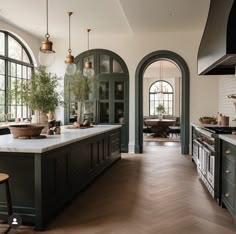 a large kitchen with wooden floors and green cabinets