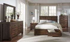 a bedroom scene with focus on the bed and dressers in the foreground,