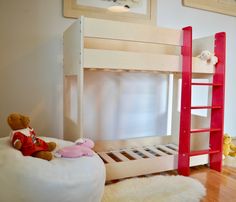 there is a bunk bed with a red ladder next to it and stuffed animals on the floor