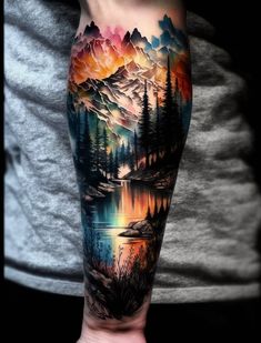 a man's arm with an image of mountains and trees on it