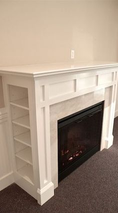 a white fireplace with shelves and a fire place in the corner on carpeted floor