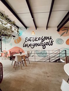 the interior of a restaurant with tables and chairs, painted on the wall behind it