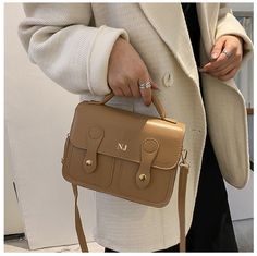 This Khaki Debbie is an everyday bag that will fit all your daily essentials. It is made from exquisite Brown Vegan leather and Gold hardware. It is a 3 way bag that can be carried by the top handle, over the shoulder or Cross body. The leather top handle is short so it can also be carried by hand. The cross body strap is made from Vegan leather for comfort and durability , it is also adjustable to cater for different heights.  Features: *Interior zippered pocket *1 Exterior pockets *1 top carry Tan Satchel With Detachable Handle For On-the-go, Leather Satchel With Silver-tone Hardware, Brown Leather Strap Satchel For On-the-go, Luxury Leather Satchel With Silver-tone Hardware, Brown Leather Satchel With Vegetable-tanned Details, Vegan Leather Bag, Satchel Bag, Leather Messenger, Messenger Bags