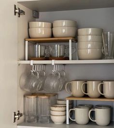 the shelves are filled with dishes and cups